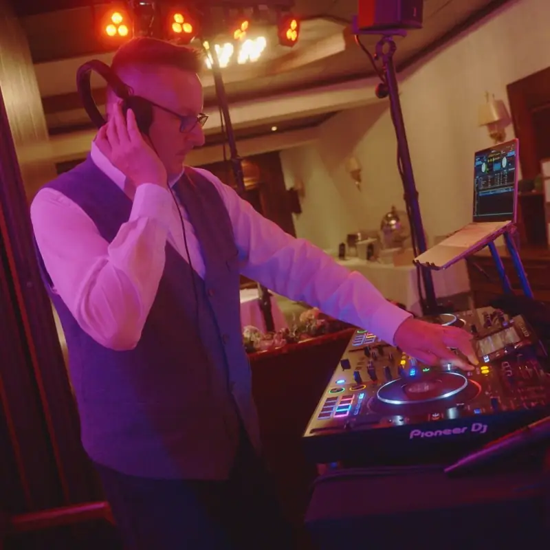 Markus Schumacher legt mit Kopfhörern am Pioneer-DJ-Pult auf, hinter ihm leuchtet die LED-Lichtleiste