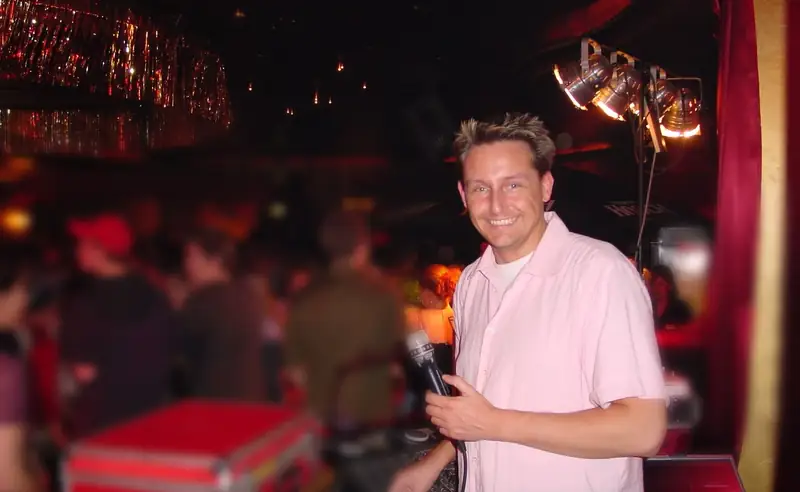 Markus Schumacher als junger DJ am Mischpult im Café Keese, die Gäste im Hintergrund sind unscharf
