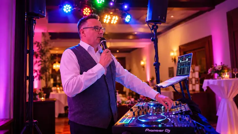 Markus Schumacher moderiert am DJ-Pult einer Hochzeitsfeier