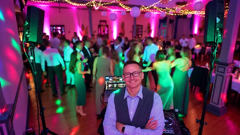 Volle Tanzfläche auf einer Hochzeit mit Lichtinszenierung, Markus Schumacher im Vordergrund